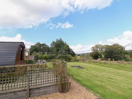 An outdoor view with a glamping pod and grassy area at Embden Pod at Banwy Glamping Llanfair Caereinion