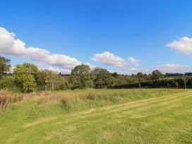 A landscape with trees and grass at Embden Pod at Banwy Glamping Llanfair Caereinion
