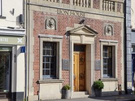 A building facade with a wooden door and windows at Lion House in Moretonhampstead