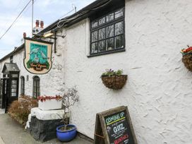 The exterior of Three Pigeons Inn with a hanging sign a blue pot plant window box and a chalkboard sign Graigfechan