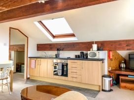 A kitchen with wooden cabinets a skylight and appliances at Heather in Graigfechan