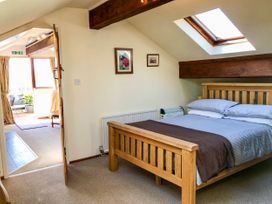 A bedroom with a wooden bed and skylight window at Heather in Graigfechan