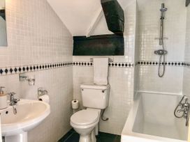 A bathroom with a sink a toilet and a bathtub with a shower at Heather in Graigfechan