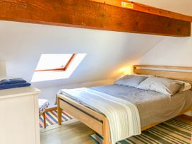 A bedroom with a wooden bed and skylight window at Heather in Graigfechan