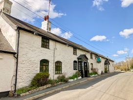 A white stone building with multiple windows and two entrances along a road on a clear day
