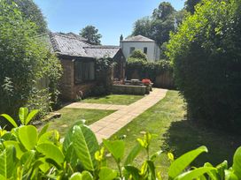 A garden with a pathway and flower planter at Claire Cottage in Gateforth near Hambleton, North Yorkshire