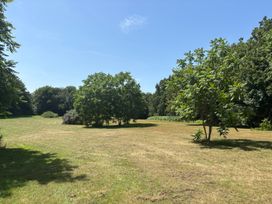 An open grassy area with trees at Claire Cottage in Gateforth near Hambleton, North Yorkshire