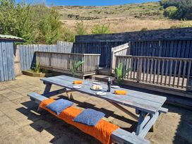 A patio area with a wooden table and benches at Bryn in Bethesda