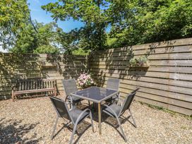 A garden with a table and chairs surrounded by wooden fencing at Stable Cottage, Narberth