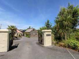 An entrance with gates and a gravel driveway at Barn Court in Templeton near Narberth