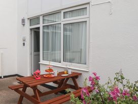 An outdoor seating area with a table and flowers at Turtle Chalet in Dawlish Warren
