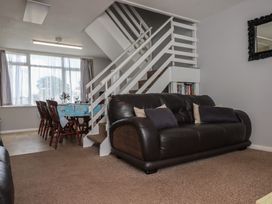 A living room with a sofa and dining area at Turtle Chalet in Dawlish Warren