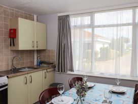 A kitchen with a sink and dining table at Turtle Chalet in Dawlish Warren