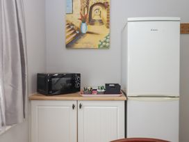 A kitchen area with a microwave and refrigerator at Turtle Chalet in Dawlish Warren