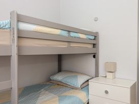 A bunk bed with bedding and a nightstand at Turtle Chalet in Dawlish Warren