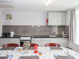 A kitchen with appliances and a dining table at Dolphin Chalet in Dawlish Warren