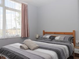 A bedroom with a bed and window at Dolphin Chalet in Dawlish Warren