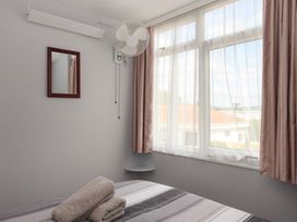 A bedroom with a mirror and fan at Dolphin Chalet in Dawlish Warren