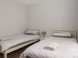 A bedroom with two beds and a bedside table at Dolphin Chalet in Dawlish Warren