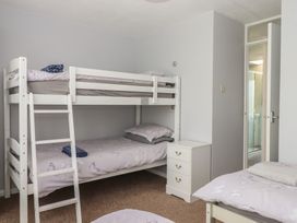A bedroom with a bunk bed and nightstand at Dolphin Chalet in Dawlish Warren