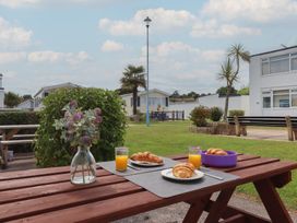 A picnic table with croissants and drinks at Dolphin Chalet Dawlish Warren