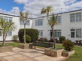 An outdoor area with palm trees and seating at Dolphin Chalet in Dawlish Warren