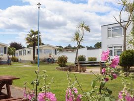 An outdoor area with holiday homes and flowers at Dolphin Chalet in Dawlish Warren