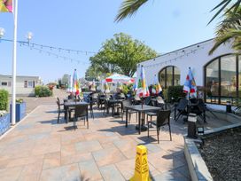 An outdoor dining area with tables and chairs at Dolphin Chalet in Dawlish Warren