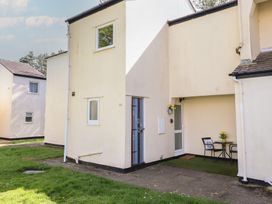 An exterior view of a house with a door and seating area at Redwood in Harlech