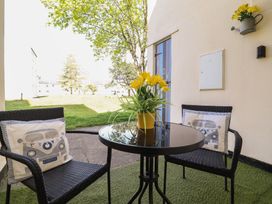 A patio with a table and chairs at Redwood in Harlech