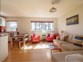 A living room with a sofa and dining area at Redwood in Harlech