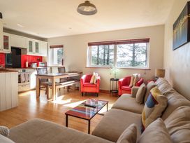 A living room with a sofa and dining area at Redwood in Harlech