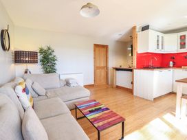 A living room with a sofa and kitchen unit at Redwood in Harlech