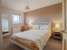 A bedroom with a bed and mirror at Redwood in Harlech