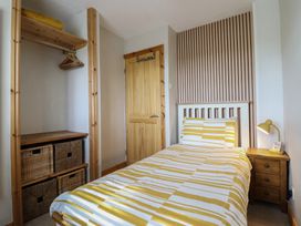 A bedroom with a bed and storage units at Redwood in Harlech