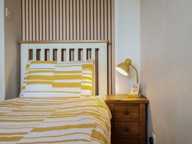 A bedroom with a bed and a lamp on a side table at Redwood in Harlech