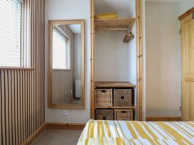 A bedroom with a mirror and storage baskets at Redwood Harlech