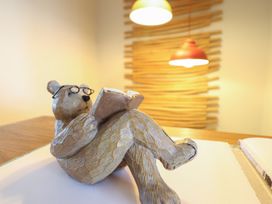 A bear figurine reading a book on a table at Redwood in Harlech