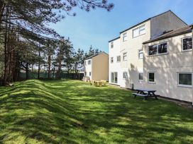 A garden with a picnic table next to a building at Redwood in Harlech