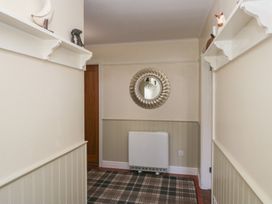 A hallway with a mirror and radiator at Laithe Cottage in Pennington near Ulverston