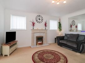 A living room with a fireplace and television at Breaking Waves in Burnham-On-Sea