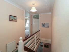 A hallway with a painting and stairs at Breaking Waves in Burnham-On-Sea