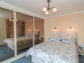 A bedroom with a bed and mirrored wardrobe at Breaking Waves in Burnham-On-Sea
