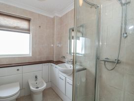 A bathroom with a shower, sink, toilet, and bidet at Breaking Waves in Burnham-On-Sea
