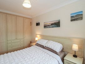 A bedroom with a bed and wardrobe at Breaking Waves in Burnham-On-Sea
