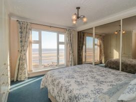 A bedroom with a bed and a view of the ocean at Breaking Waves in Burnham-On-Sea