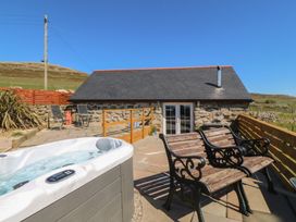 An outdoor area with a hot tub and seating at Ty Coch in Llanaelhaearn near Trefor, Caernarfon