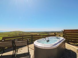 A hot tub with outdoor seating and scenic view at Ty Coch in Llanaelhaearn near Trefor, Caernarfon