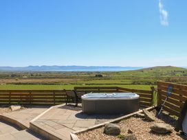 An outdoor area with a hot tub and a bench at Ty Coch in Llanaelhaearn near Trefor, Caernarfon