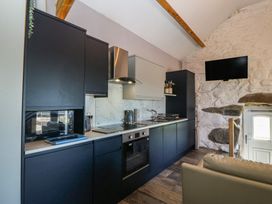A kitchen with modern appliances and a television at Ty Coch in Llanaelhaearn near Trefor, Caernarfon
